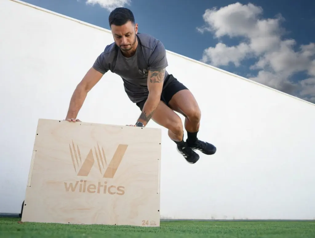 Deportista realizando box jumps sobre el cajón de salto JumpBox de madera de Wiletics en un entrenamiento de potencia