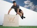Deportista realizando box jumps sobre el cajón de salto JumpBox de madera de Wiletics en un entrenamiento de potencia